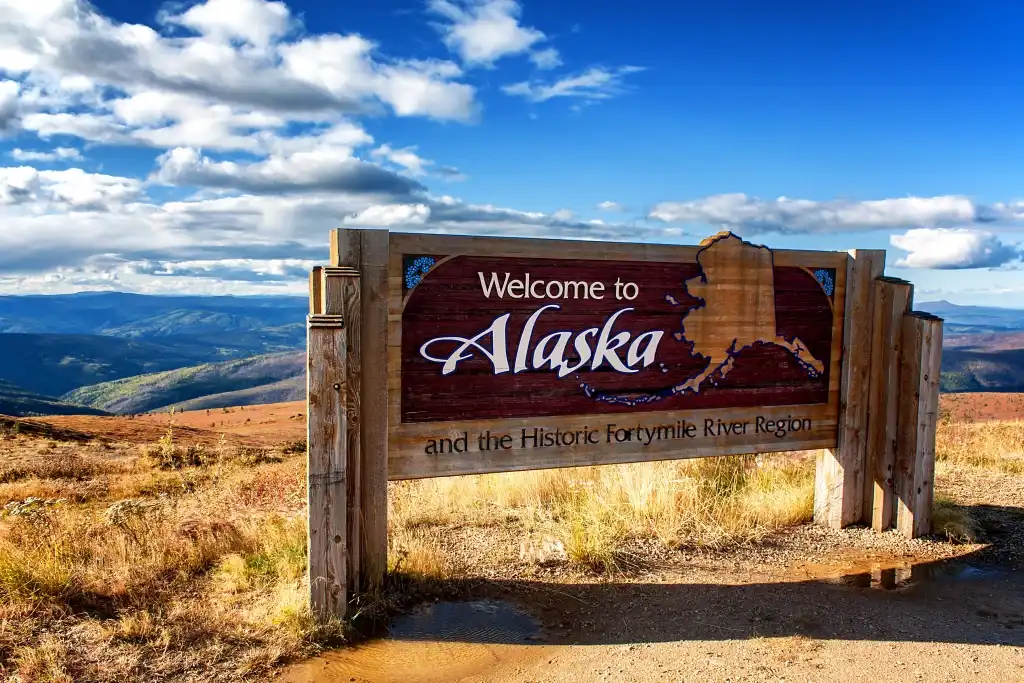 Best Renters Insurance in Alaska for 2026 Welcome to Alaska sign with scenic mountain landscape