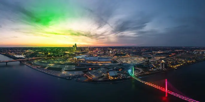 Aerial view of Omaha Nebraska skyline at dusk with colorful bridge lights and Missouri River